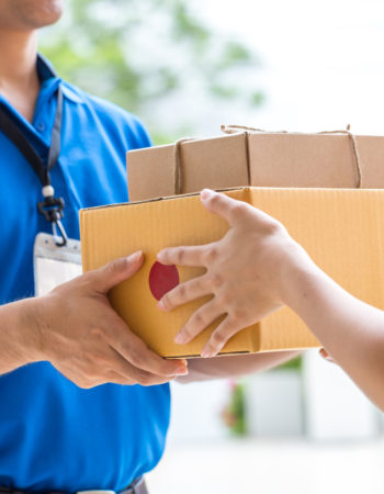 Woman hand accepting a delivery of boxes from deliveryman